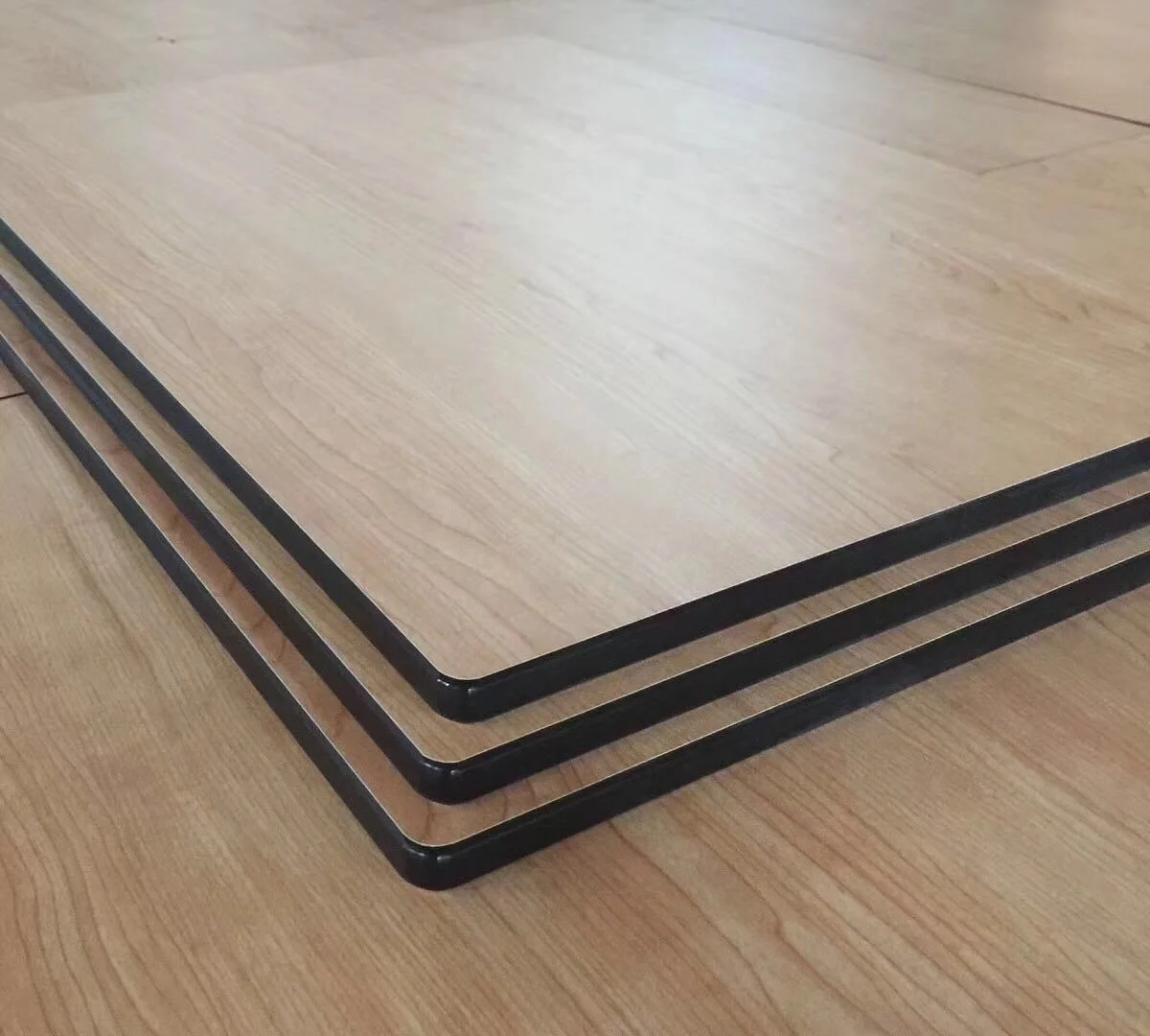 The cut edge of a compact HPL panel, showing the black phenolic core
